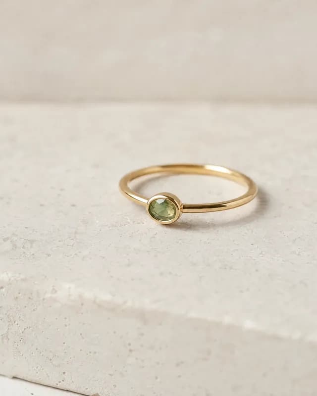 A gold ring with an oval green stone, re-shot in Latent's Minimal look